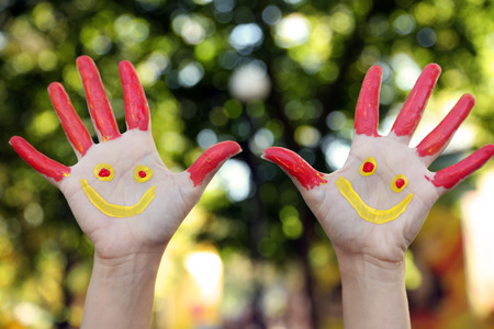 Smiling colorful hands on natural backgroundの写真素材
