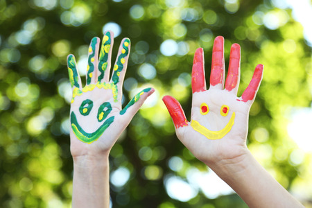 Smiling colorful hands on natural backgroundの写真素材