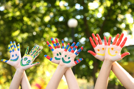 Smiling colorful hands on natural backgroundの写真素材