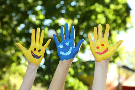 Smiling colorful hands on natural backgroundの写真素材