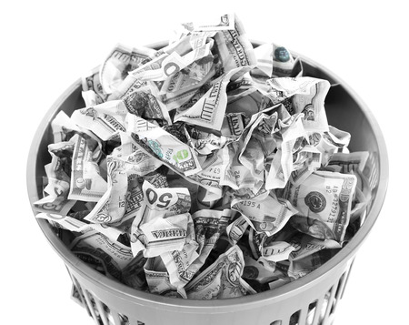 Money in dustbin isolated on whiteの写真素材