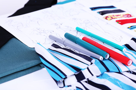 Sketches of clothes and fabric samples on table
