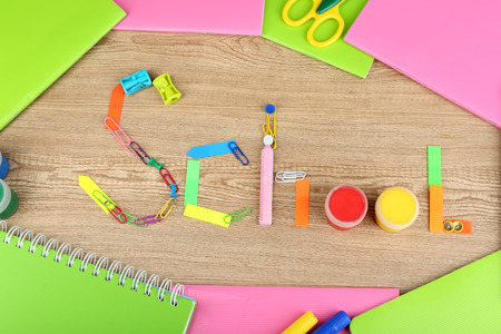 Inscription school lined of school supplies on wooden background