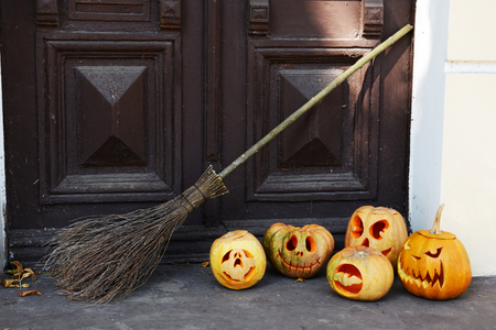 Pumpkin and broom for holiday Halloween on old wooden door backgroundの写真素材