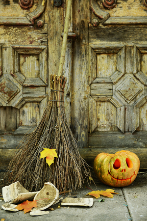 Pumpkin and broom for holiday Halloween on old wooden door backgroundの写真素材