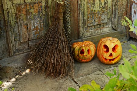 Pumpkin and broom for holiday Halloween on old wooden door backgroundの写真素材