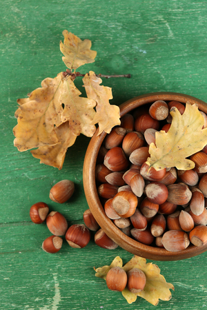 Hazelnuts in wooden bowl on wooden backgroundの写真素材