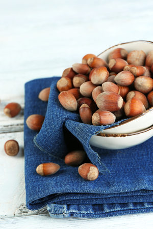 Hazelnuts on plate on napkin on wooden backgroundの写真素材