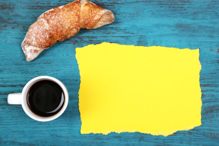Composition of coffee, fresh croissant and paper card on wooden backgroundの写真素材