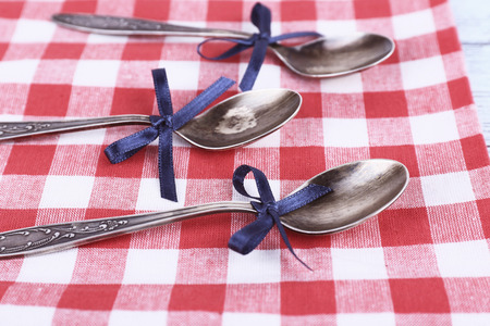 Metal spoons on checkered fabric backgroundの写真素材
