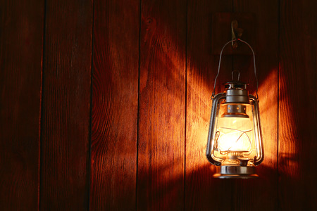 Lantern hanging on hook on wooden wallの写真素材