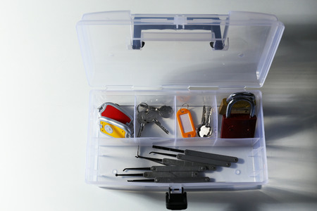 Set of keys, lock picks in box on white table