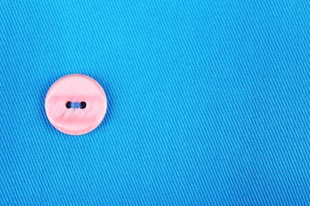 Button on blue cloth, close up