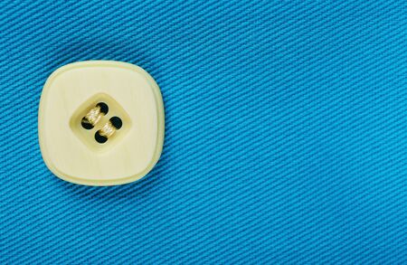 Button on blue cloth, close upの写真素材