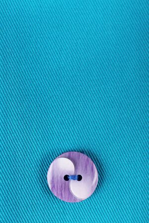 Button on blue cloth, close up