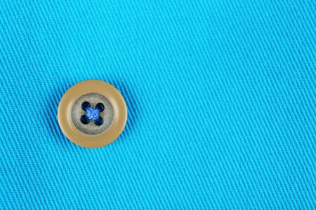 Button on blue cloth, close up