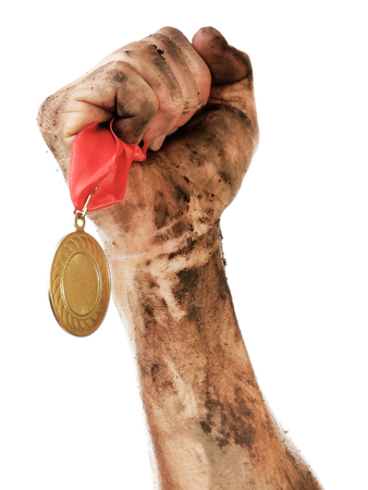 Golden medal in hand isolated on whiteの写真素材