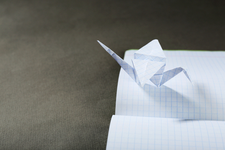 Origami cranes on notebook on grey backgroundの写真素材