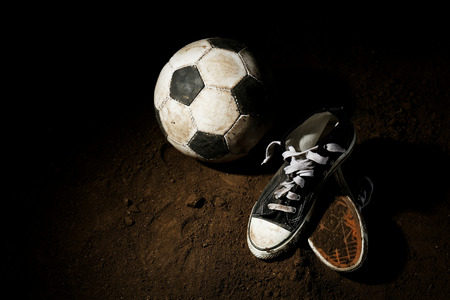 Soccer ball on ground on dark backgroundの写真素材