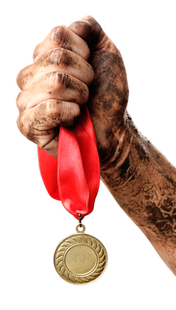 Golden medal in hand isolated on whiteの写真素材