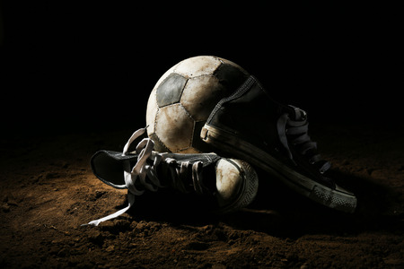 Soccer ball on ground on dark backgroundの写真素材