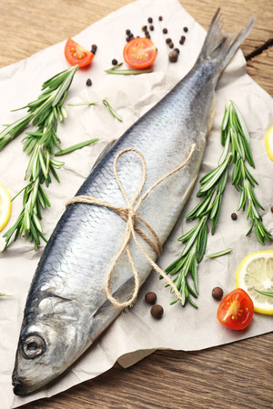 Fresh raw fish and food ingredients on tableの写真素材