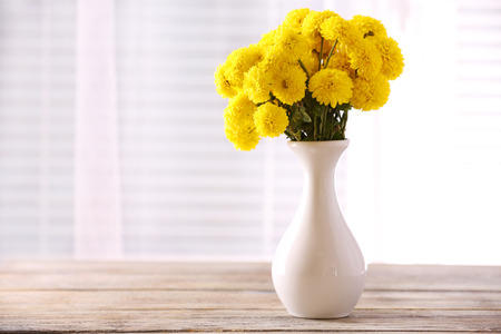 Beautiful flowers in vase with light from window