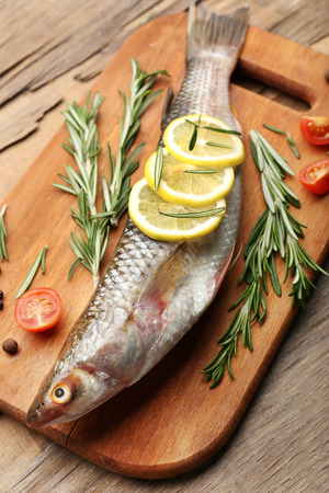 Fresh raw fish and food ingredients on tableの写真素材