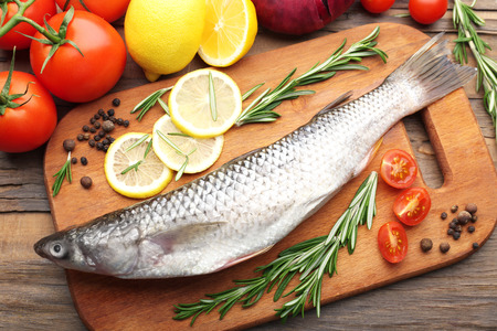 Fresh raw fish and food ingredients on table