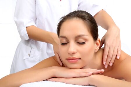 Masseur doing massage on woman body isolated on white.の写真素材