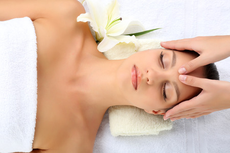 Portrait of beautiful woman taking head massageの写真素材