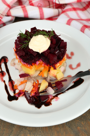 Russian herring salad on plate on wooden table backgroundの写真素材