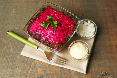 Russian herring salad in glass bowl on wooden table backgroundの写真素材