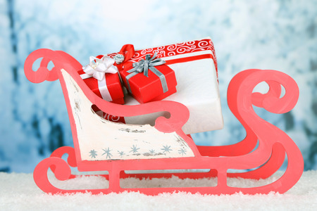 Wooden toy sledge with Christmas gifts  on nature backgroundの写真素材