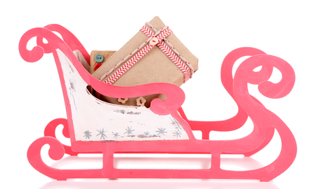 Wooden toy sledge with Christmas gifts, isolated on whiteの写真素材