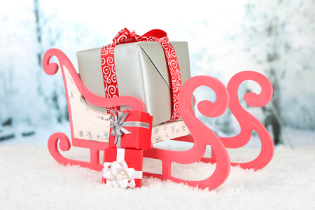 Wooden toy sledge with Christmas gifts  on nature backgroundの写真素材