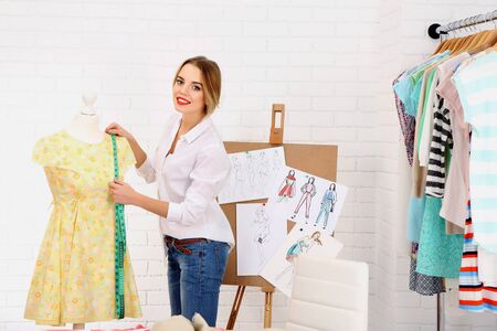 Beautiful young dressmaker in workroom