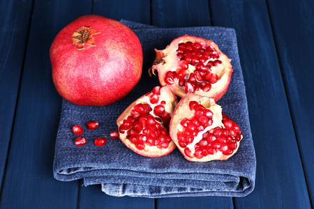 Juicy ripe pomegranates on blue wooden tableの写真素材