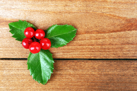 European Holly (Ilex aquifolium) with berries on wooden backgroundの写真素材