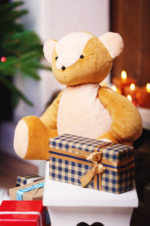 Teddy bear with Christmas gifts in roomの写真素材