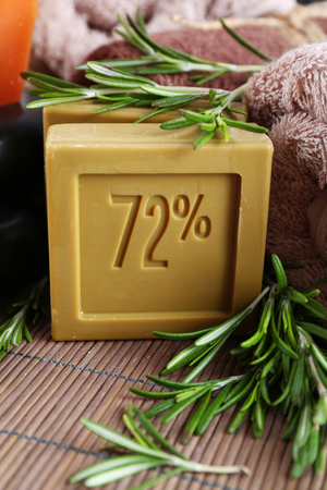 Handmade soap with the branches of rosemary, spa stones and towels, close-up. Rosemary spa conceptの写真素材