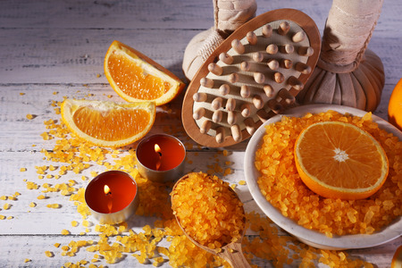 Accessories for massage therapy with candle light and bowl of bath salt on color wooden backgroundの写真素材