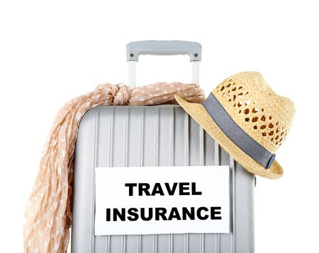 Travel suitcase and tourist stuff with inscription  travel insurance isolated on whiteの写真素材