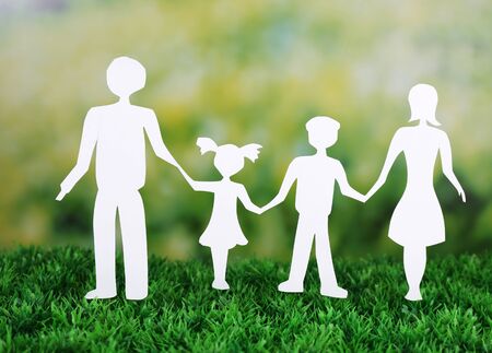 Paper family on green grass on light backgroundの写真素材