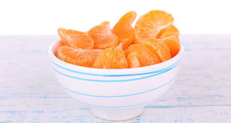 Slices mandarin on color wooden surface, isolated on white white backgroundの写真素材