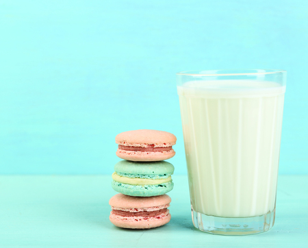 Assortment of gentle colorful macaroons and glass with milk on color wooden backgroundの写真素材