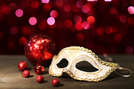 Beautiful carnival mask on table on red backgroundの写真素材