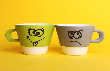 Emotional cups on yellow backgroundの写真素材