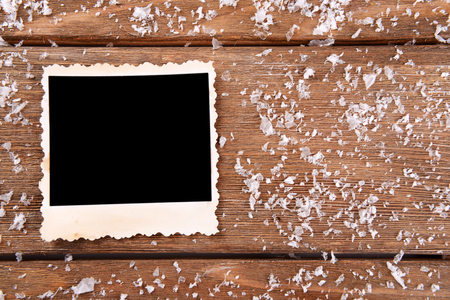 Blank photo frame and snowflakes on wooden table backgroundの写真素材