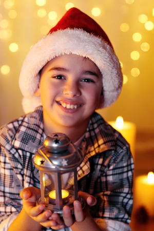 Little boy sitting near fireplace in roomの写真素材